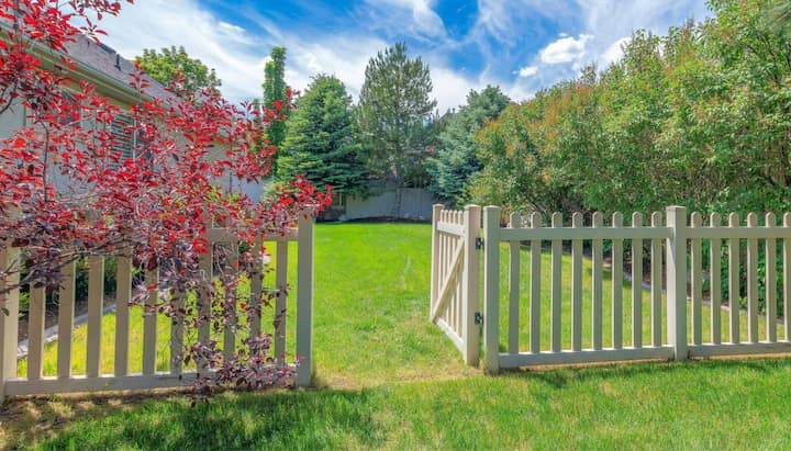 A functional fence gate providing access to a well-maintained backyard, surrounded by a wooden fence in Cary